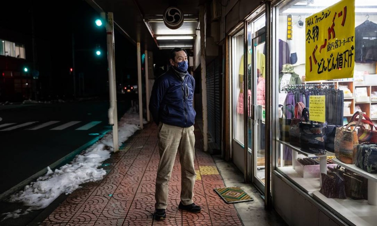 Shinichi Sato do lado de fora de sua loja de roupas, na Ilha Sado, onde sua família vive há dez gerações Foto: Shiho Fukada / The New York Times