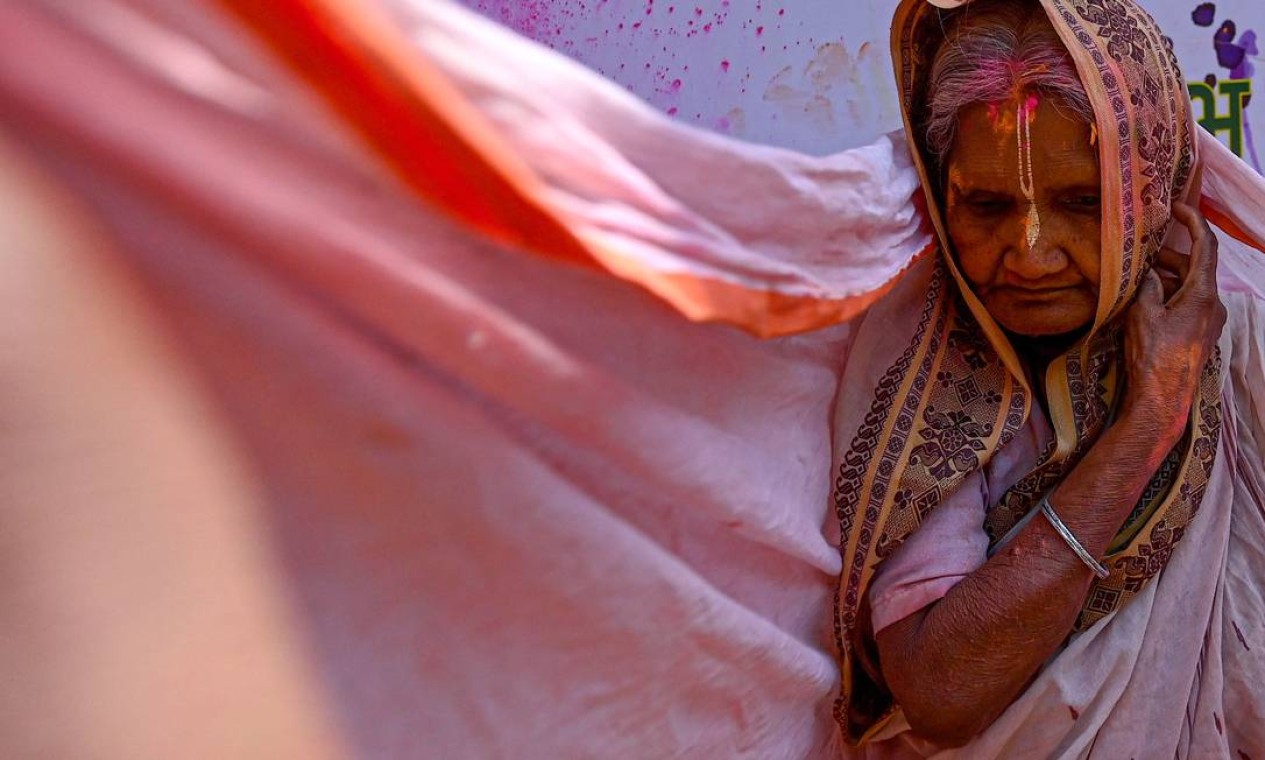 Vviúva manchada com Gulal (pó de cor) participa das celebrações do Holi, o festival de cores da primavera hindu, em um templo em Vrindavan, Índia Foto: MONEY SHARMA / AFP
