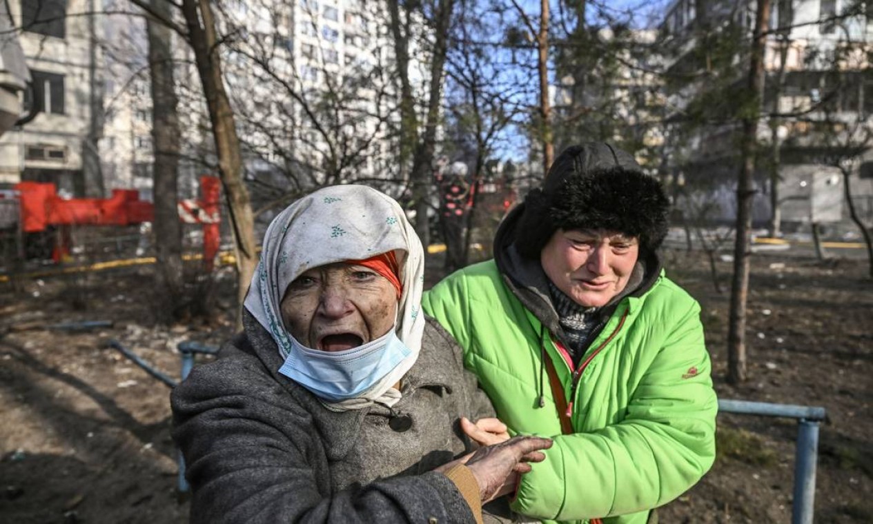 Mulher é resgatada de prédio de apartamentos em chamas em Kiev Foto: ARIS MESSINIS / AFP