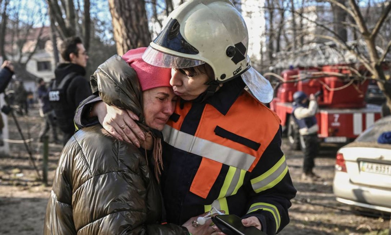 MMorador resgatado de prédio em chamas é confortado por combatente Foto: ARIS MESSINIS / AFP