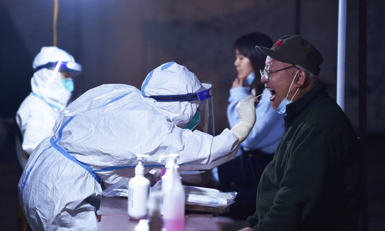 Morador passa por um teste de ácido nucleico para o coronavírus Covid-19 em Nanjing, na província de Jiangsu, leste da China, que colocou mais de 40 milhões de pessoas em quarentena rigorosa depois de detectar 1.000 por dia durante uma semana Foto: STR / AFP