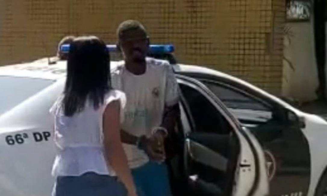 Alexandre ao sair do carro da polícia, pouco depois de ser preso Foto: Reprodução