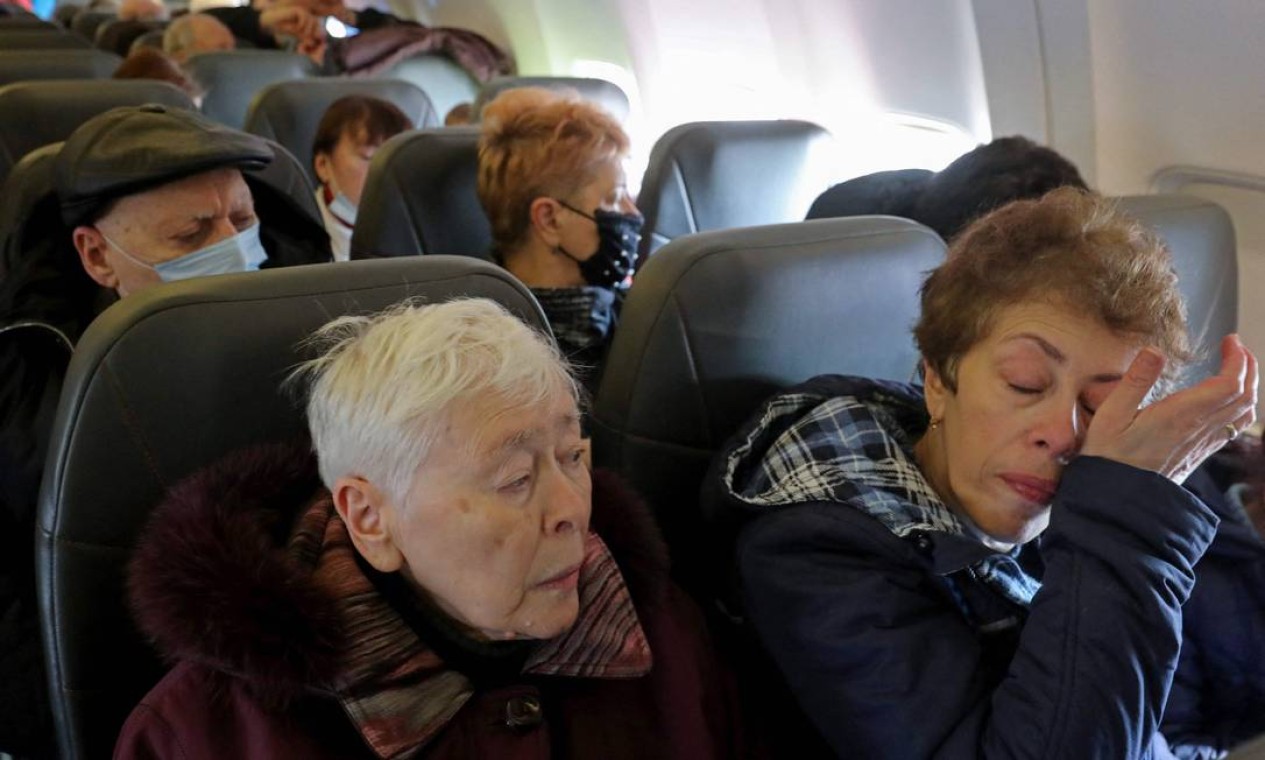 Refugiados judeus ucranianos, que fugiram da guerra em seu país, emocionam-se durante voo para Israel da capital moldava Chisinau Foto: GIL COHEN-MAGEN / AFP