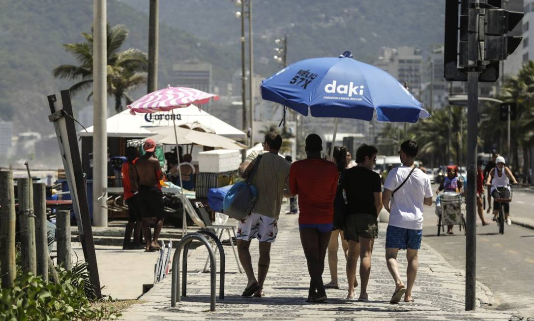 Banhistas caminham na sombra da barraca de praia em Ipanema Foto: Rebecca Alves / Agência O Globo
