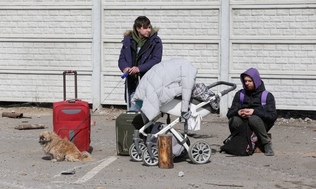 Refugiados descansam em uma rua ao deixar a cidade de Mariupol Foto: ALEXANDER ERMOCHENKO / REUTERS