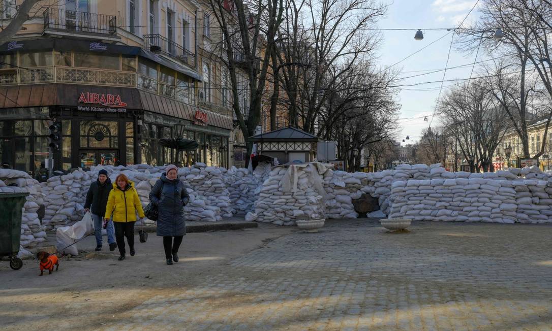 Pessoas passam por barricadas em Odessa, no litoral ucraniano do Mar Negro, onde Svetlana Ruseishvili, radicada no Brasil há dez anos, ainda tem parentes Foto: BULENT KILIC / AFP