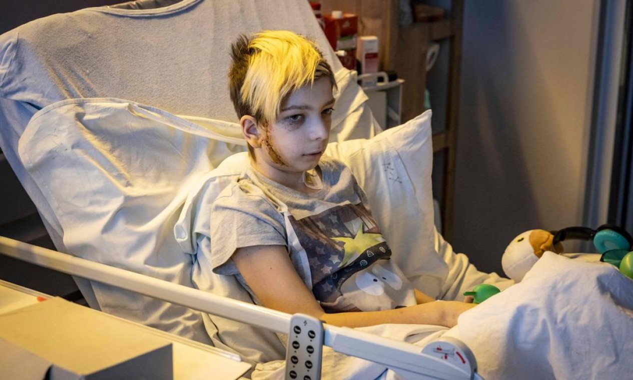 Volodymyr, 13 anos, senta-se em uma cama de hospital após ser ferido, em Kiev. O carro de sua família foi pego em um tiroteio entre tropas russas e ucranianas na capital invadida Foto: FADEL SENNA / AFP