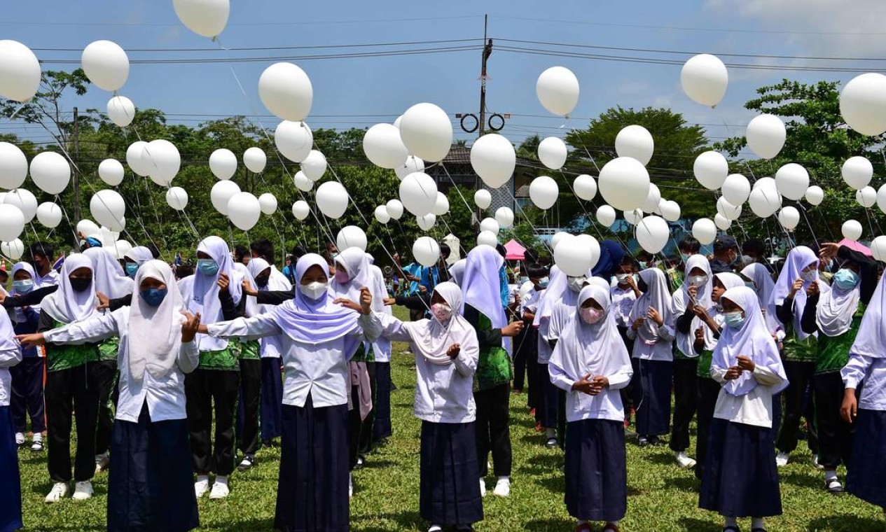 Estudantes seguram balões brancos durante uma manifestação contra a violência, após incidentes recentes entre guardas florestais tailandeses e suspeitos separatistas, no distrito de Ra-ngae, na província de Narathiwat, no sul da Tailândia Foto: MADAREE TOHLALA / AFP