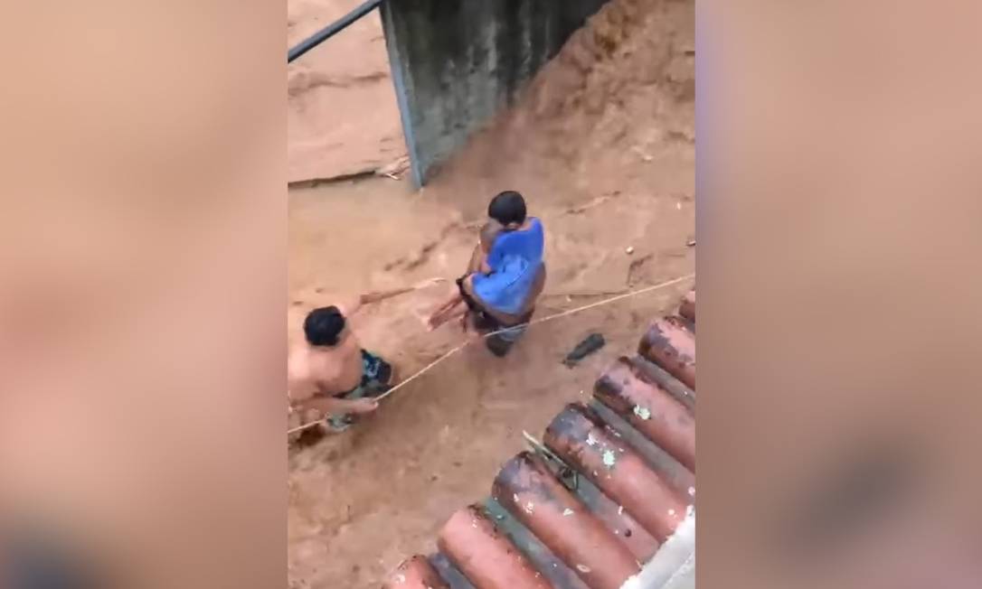 Vizinhos usaram uma corda para resgatar moradores de casas isoladas por enchente Foto: Reprodução