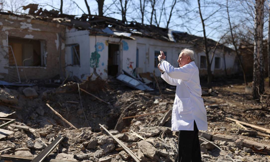Médico Anatolii Pavlov tira fotos de um hospital psquiátrico destruído após bombardeio de tropas russas em Mykolaiv, Ucrânia Foto: NACHO DOCE / REUTERS