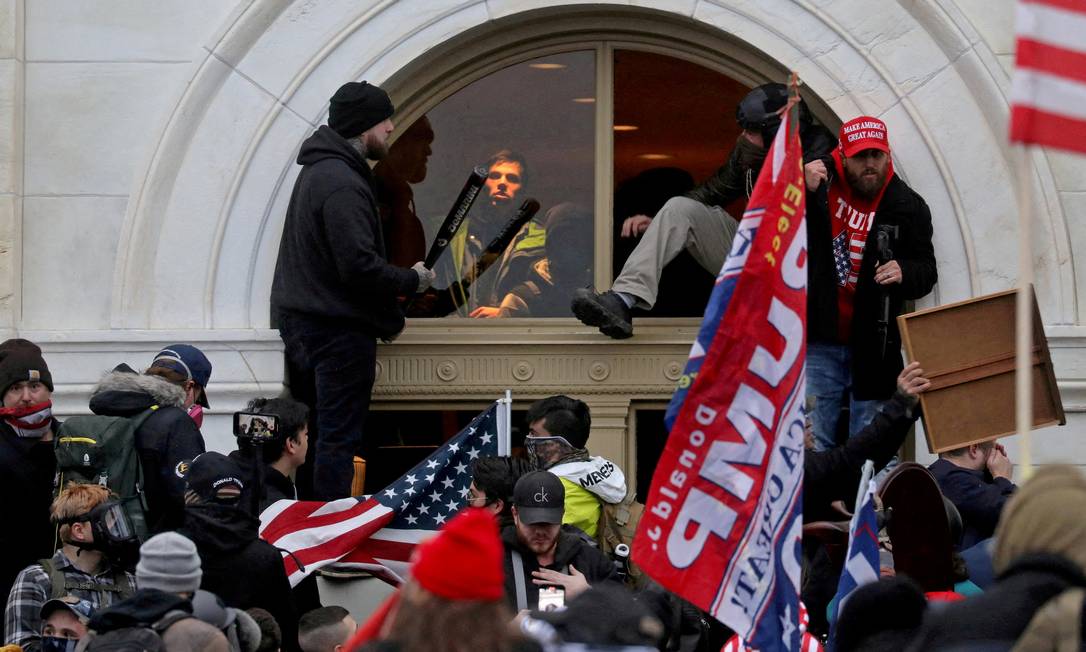 Multidão de apoiadores do então presidente dos EUA Donald Trump entra por uma janela durante a invasão do Capitólio dos EUA Foto: Leah Millis / Reuters / 6-1-2021