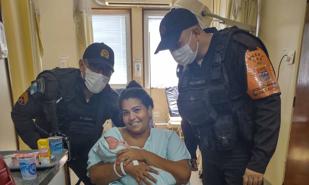 Cícera Silva segura a pequena Aylla, ao lado dos policiais que a levaram em segurança ao hospital Foto: Reprodução