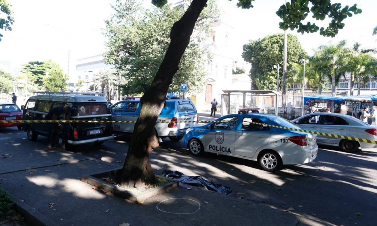 O local do crime é cercado por carros da PM Foto: Fabiano Rocha / Agência O Globo