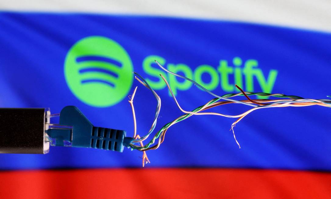 Cabo de Ethernet avariado é visto em frente à bandeira russa com logo do Spotify Foto: DADO RUVIC / REUTERS