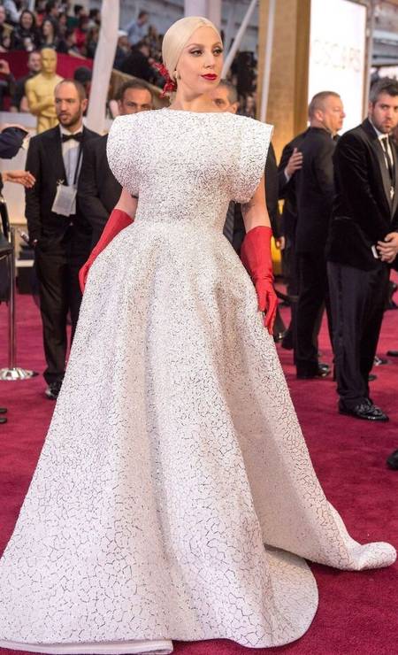 Lady Gaga sempre à frente, selecionou, em 2015, um vestido branco assinado pelo estilista Azzedine Alaïa combinado com uma luva vermelha. As luvas acabaram virando meme Foto: GettyImages