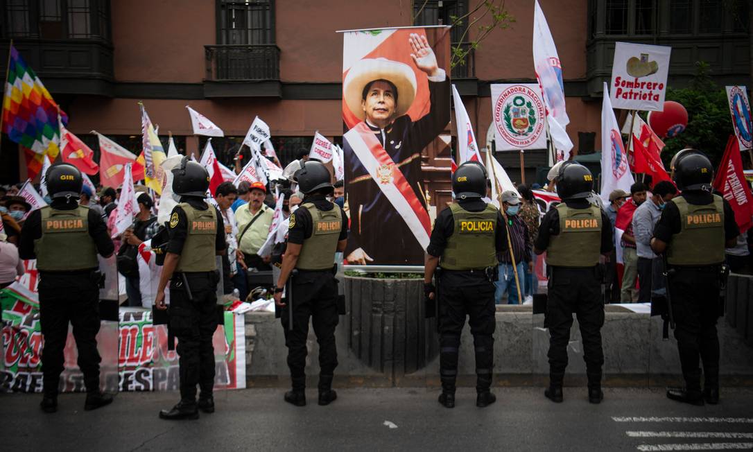 Policiais ficam de guarda enquanto apoiadores do presidente peruano, Pedro Castillo, protestos do lado de fora do Congresso Foto: ERNESTO BENAVIDES / AFP