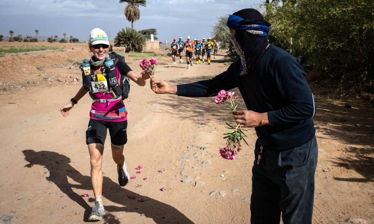 Competidora recebe flores ao participar da Etapa 4 (85,8 quilômetros em dois dias) da 36ª edição da Maratona das Areias, que são 250 km, entre Nord El Maharch e Jebel Mraier no deserto do Saara marroquino, centro de Marrocos Foto: JEAN-PHILIPPE KSIAZEK / AFP