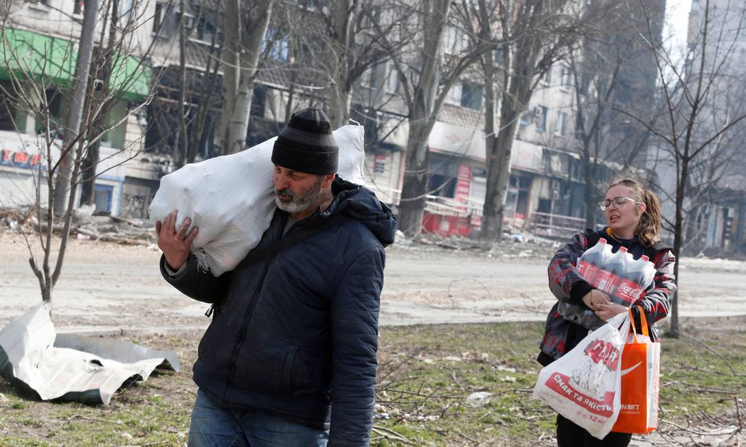 Moradores carregam alimentos na cidade portuária sitiada de Mariupol, Ucrânia Foto: ALEXANDER ERMOCHENKO / REUTERS