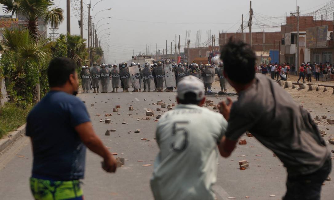 Polícia de choque confronta manifestantes durante confrontos após uma greve parcial de transportadores de carga e passageiros, em Ate, perto de Lima, no Peru Foto: GIAN MASKO / AFP