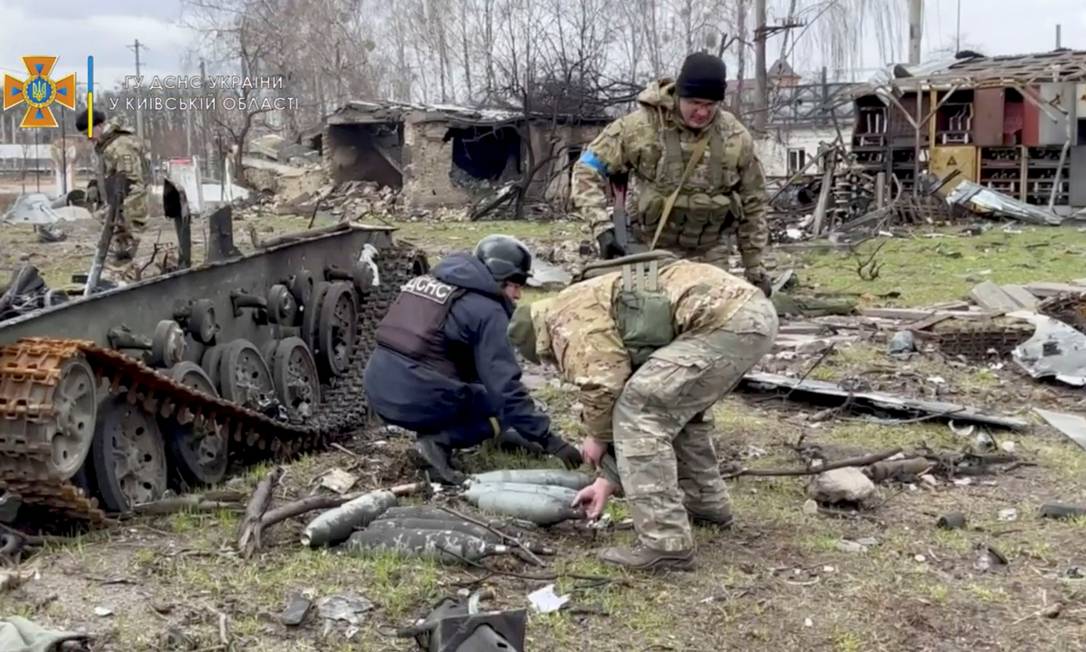 Membros do Serviço de Emergência da Ucrânia coletam munições após a retirada da Rússia em Bucha, Ucrânia Foto: SERVIÇO DE EMERGÊNCIA DA UCRÂNIA / via REUTERS
