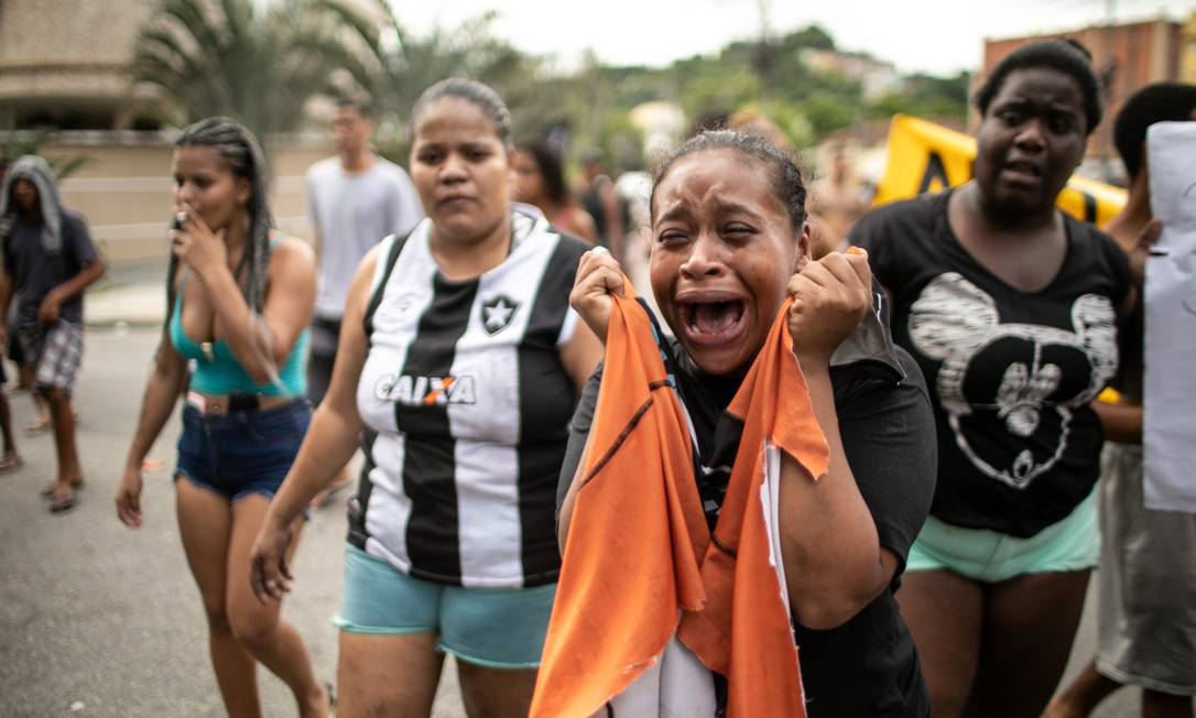 Durante protesto, Caroline Camargo da Silva, irmã de Cauã, segura a blusa que o jovem usava no momento em que foi morto com um tiro Foto: Brenno Carvalho / Agência O Globo