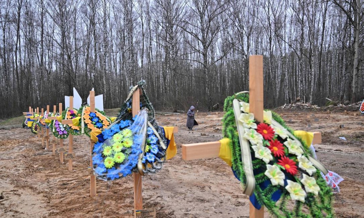 Morador procura os túmulos de parentes em um cemitério em Chernigiv, norte da Ucrânia. Autoridades da cidade estimam que cerca de 350 civis foram mortos na cidade desde o início da invasão de russa Foto: SERGEI SUPINSKY / AFP