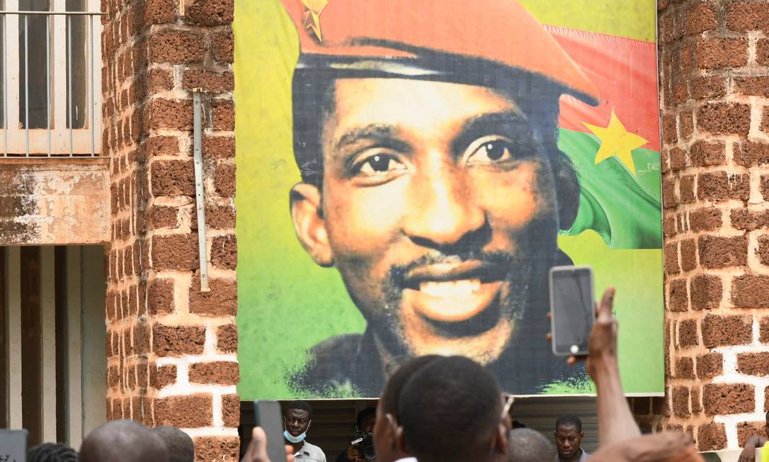 Apoiadores do ex-presidente de Burkina Faso, Thomas Sankara, em frente a um quadro dele após a Justiça do país sentenciar o ex-chefe de Estado, Blaise Compaoré, à prisão perpétua por participar do assassinato de seu predecessor Foto: Anne Mimault / Reuters