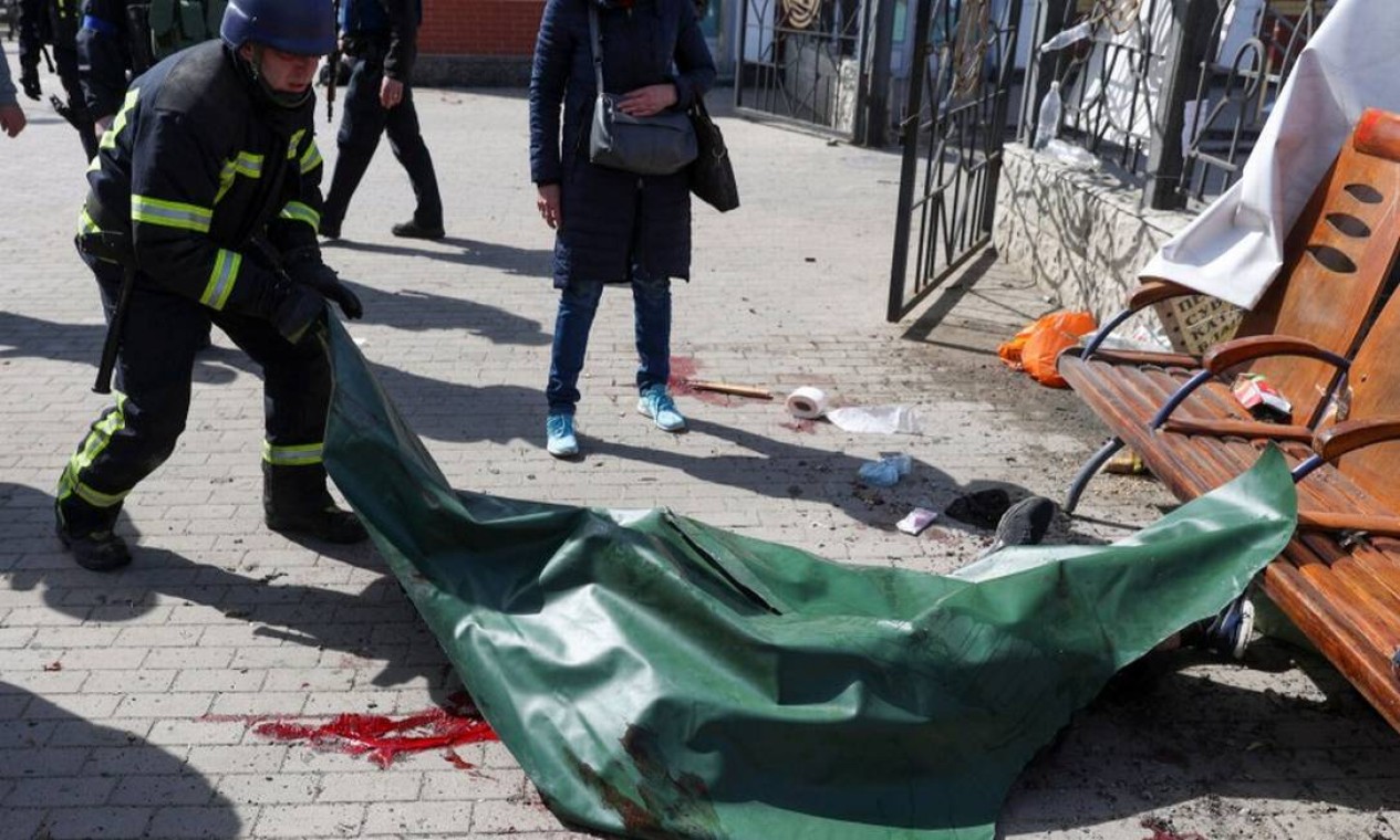 Bombeiro cobre corpo de vítima de ataque a estação de trem em Kramatorsk Foto: ANATOLII STEPANOV / AFP