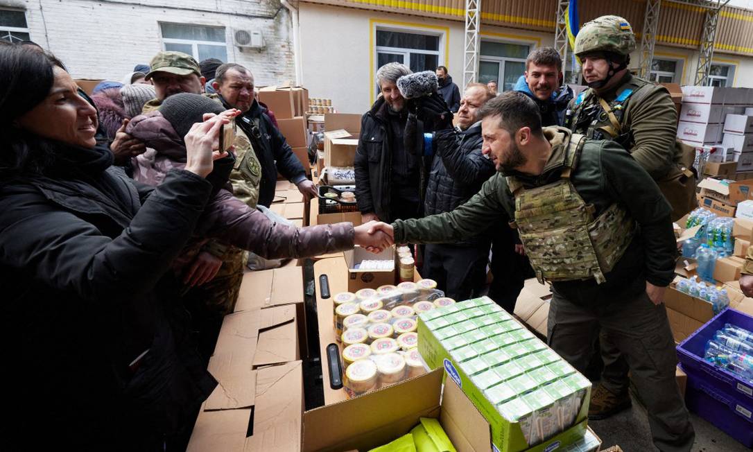 Presidente da Ucrânia, Volodymyr Zelensky, entrega alimentos a moradores da cidade de Bucha, nos arredores de Kiev, no dia 4 de abril Foto: STR / AFP