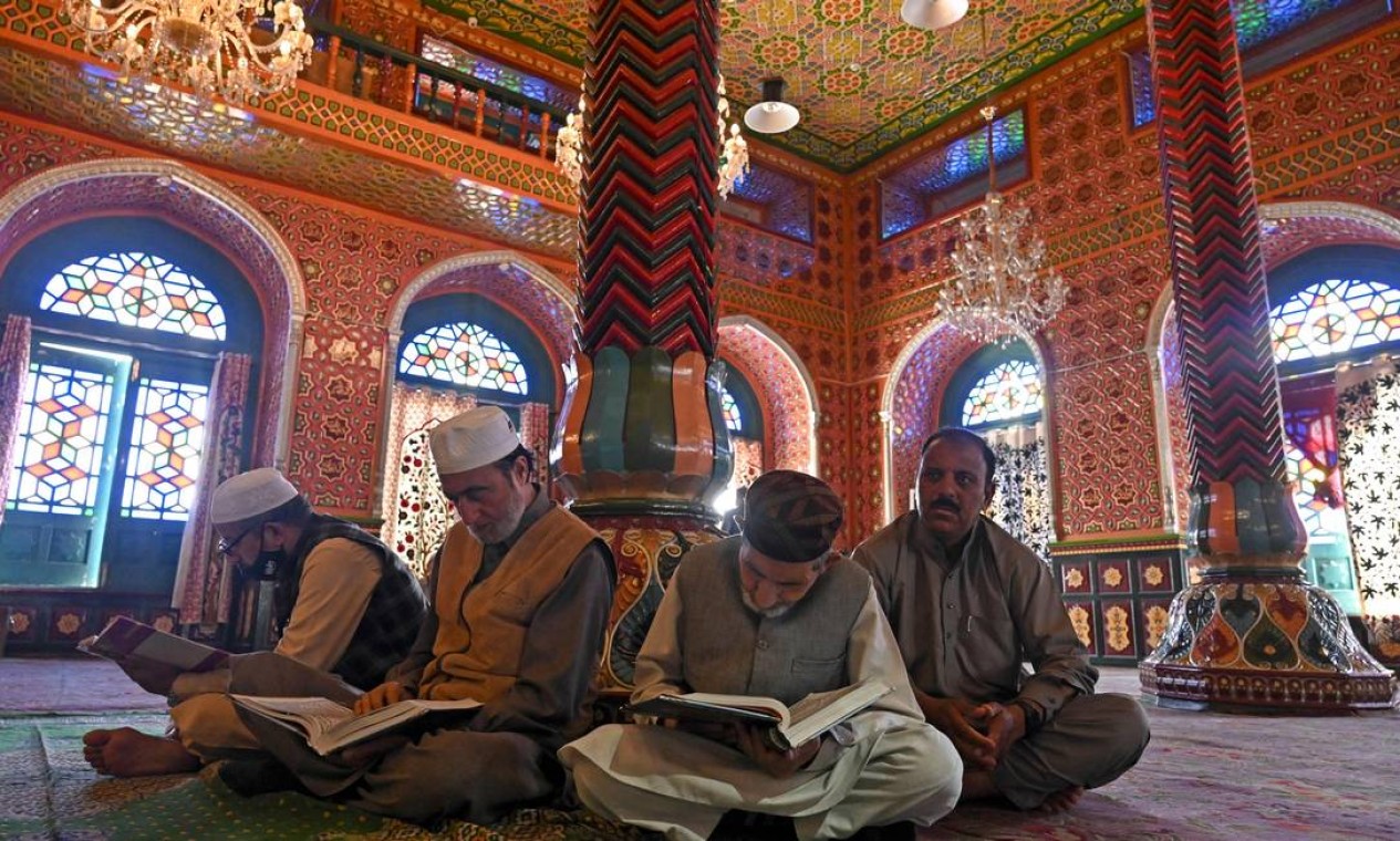 Devotos muçulmanos leem o Alcorão no santuário Sheikh Abdul Qadir Jilani, durante o mês sagrado do Ramadã, em Srinagar Foto: TAUSEEF MUSTAFA / AFP