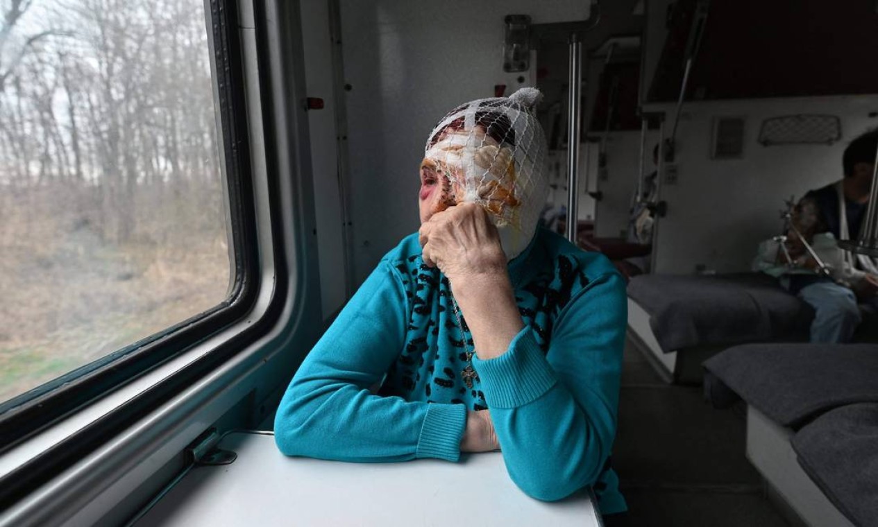 Praskovya, 77 anos, observa pela janela de um trem de evacuação médica a caminho da cidade de Lviv, no oeste da Ucrânia Foto: GENYA SAVILOV / AFP