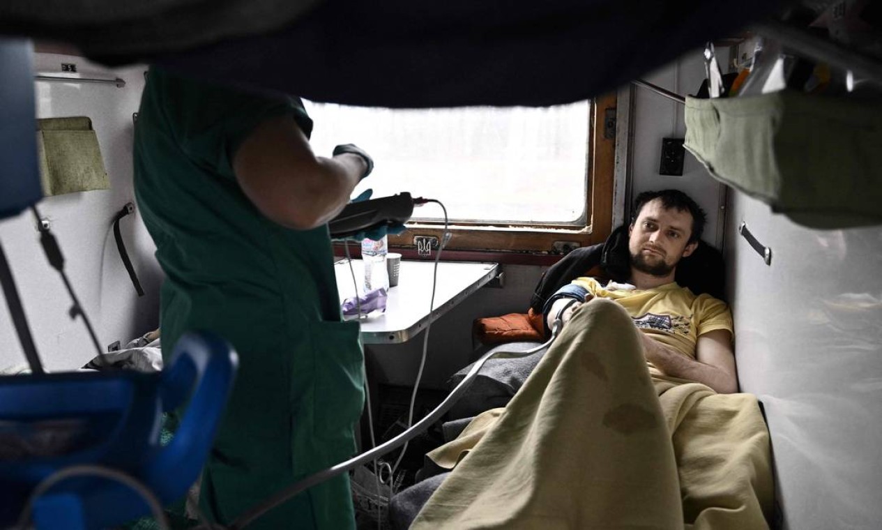 Uma enfermeira do MSF cuida de uma paciente. Trem hospital atendendo alguns pacientes idosos de instituições de longa permanência, mas a maioria é de feridos nos ataques russos Foto: GENYA SAVILOV / AFP