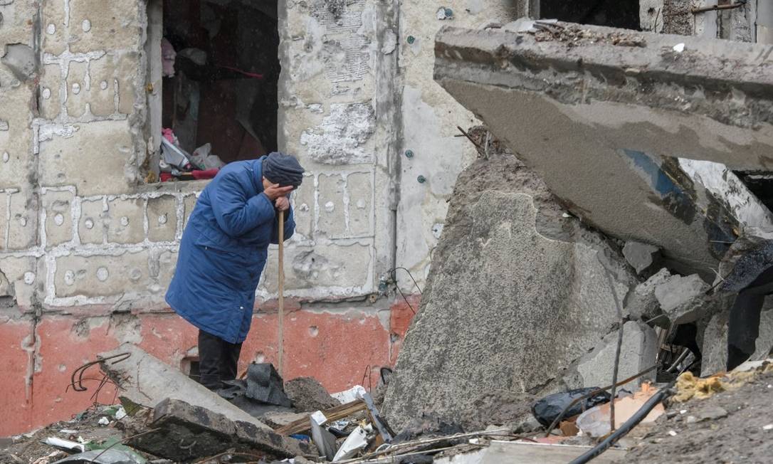 Mulher chora em meio a destroços de prédio destruído na Guerra na Ucrânia Foto: STRINGER / REUTERS