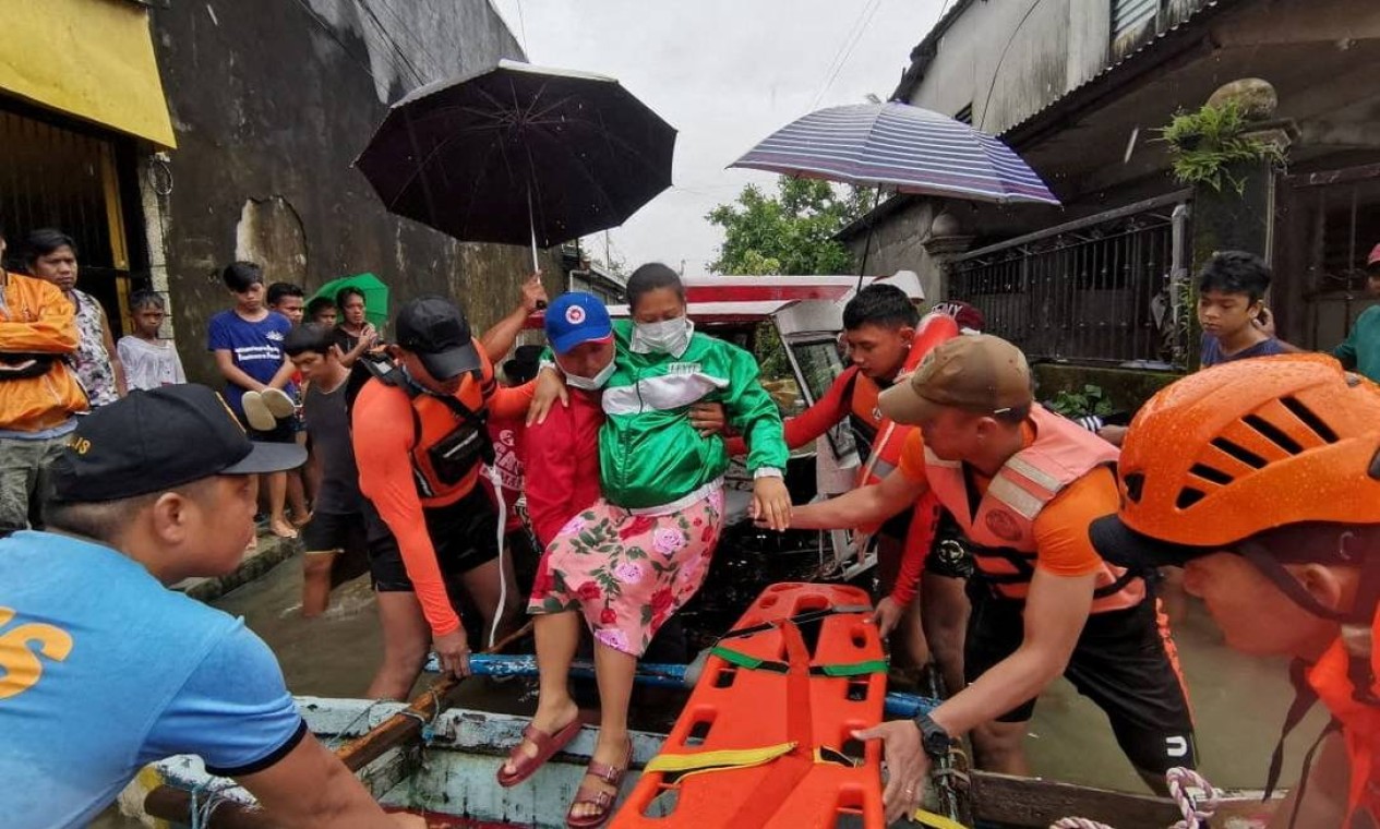 Equipe de resgate ajuda uma mulher em uma jangada em meio a inundações, após a tempestade tropical Megi, na província de Leyte, Filipinas Foto: PHILIPPINE COAST GUARD / via REUTERS
