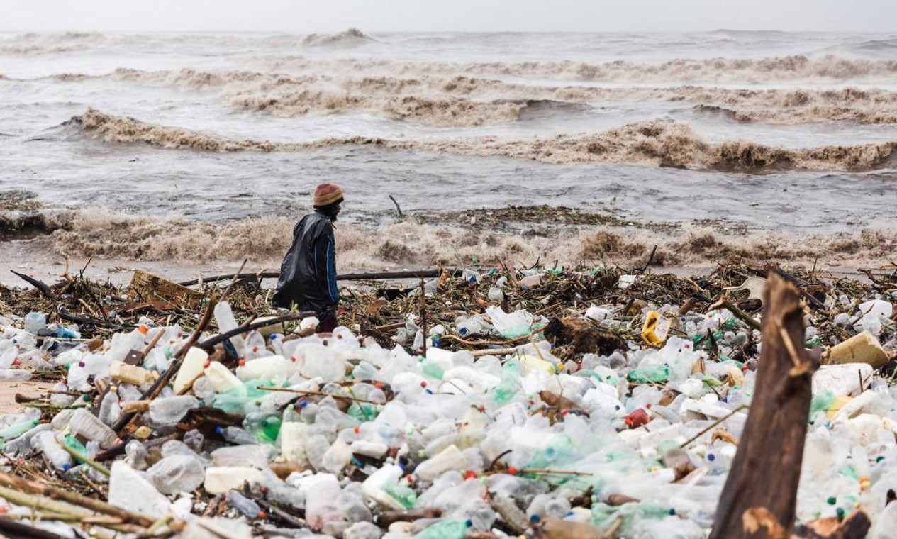Homem é visto vasculhando destroços na praia da Lagoa Azul após fortes chuvas e ventos em Durbanl, onde, pelo menos, 45 pessoas morreram depois de tempestades que atingiram a cidade portuária sul-africana Foto: RAJESH JANTILAL / AFP
