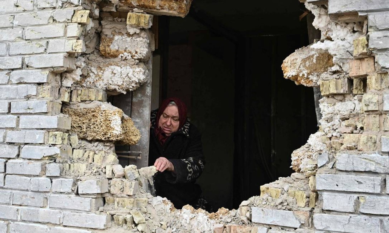 A ucraniana Nadiya, 65, mostra um buraco em uma casa após um bombardeio na vila de Zalissya, a nordeste de Kiev Foto: GENYA SAVILOV / AFP
