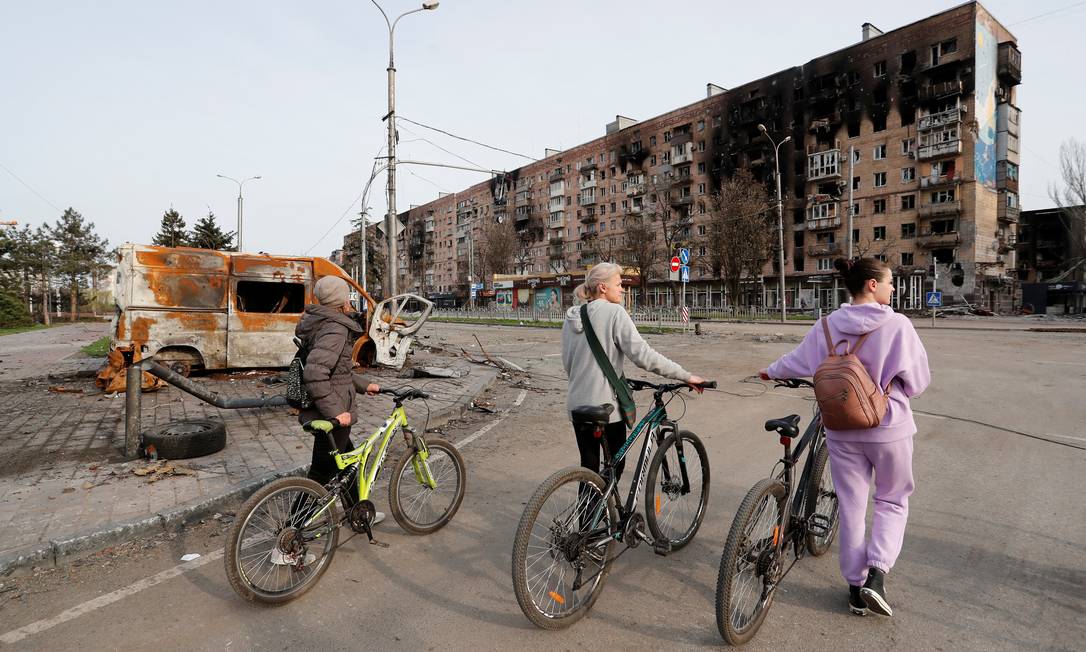 Moradores de Mariupol circulam em área residencial bombardeada pelas tropas russas Foto: ALEXANDER ERMOCHENKO / REUTERS