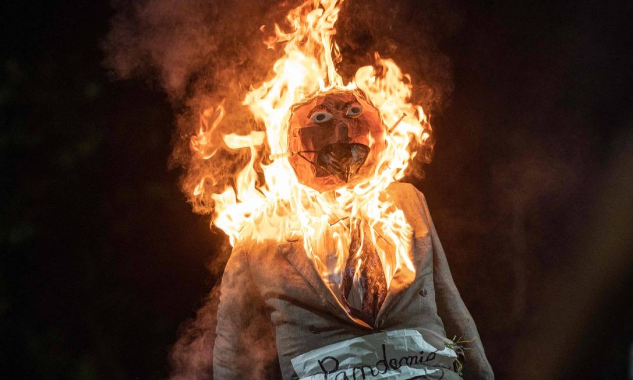 Manequim representando a pandemia de COVID-19 é incendiado durante a tradicional "queima de Judas", a figura bíblica que supostamente traiu Jesus, durante as celebrações da Páscoa, no bairro Pedregal, em Caracas, capital da Venezuela Foto: FEDERICO PARRA / AFP