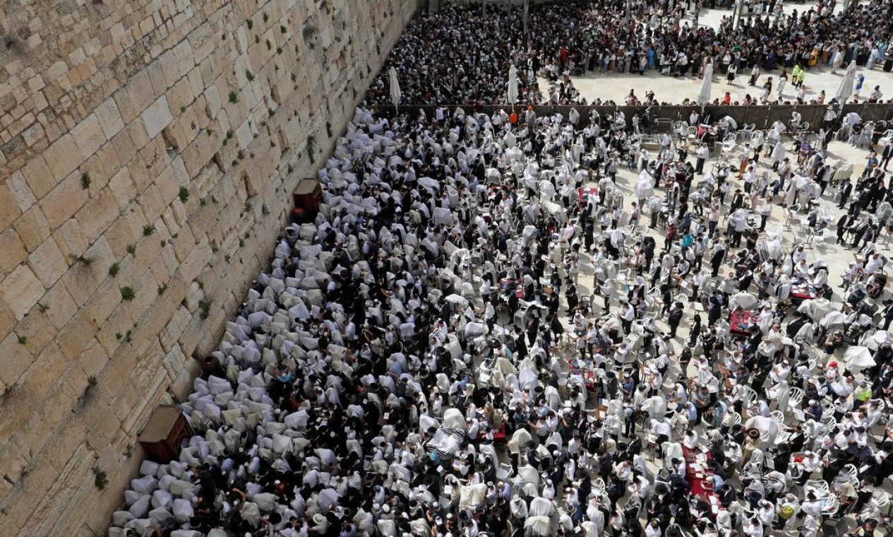 Adoradores judeus participam da oração Cohanim (bênção do padre) durante o feriado da Páscoa no Muro das Lamentações, na Cidade Velha de Jerusalém Foto: GIL COHEN-MAGEN / AFP