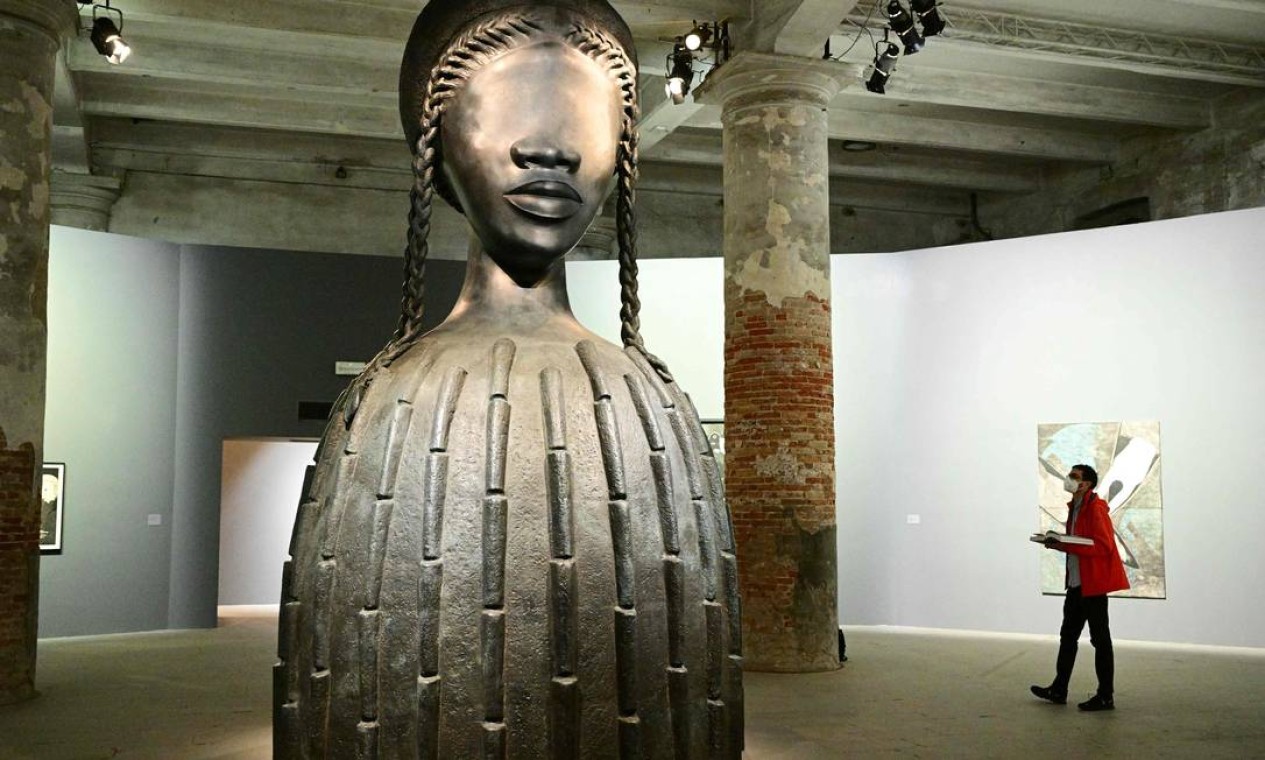 Visitante observa a "Brick House", uma escultura de bronze da artista Simone Leigh, durante apresentação da 59ª Bienal de Arte de Veneza Foto: VINCENZO PINTO / AFP
