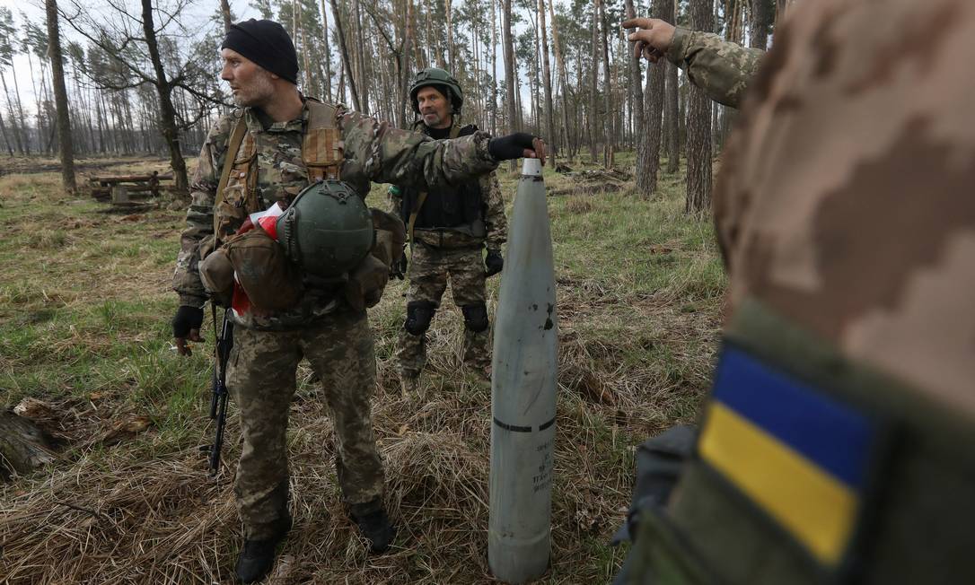 Sabotador segura parte de um míssil russo lançado durante invasão da Rússia na região de Kiev Foto: STRINGER / REUTERS