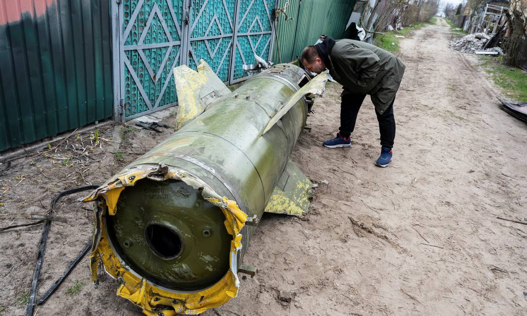 Homem observa os restos de um míssil russo, enquanto a invasão russa da Ucrânia continua, na vila de Kozarovychi, perto de Kiev Foto: VIACHESLAV RATYNSKYI / REUTERS