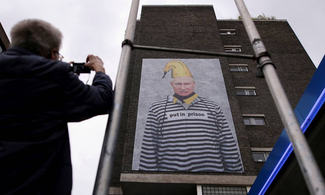 Protesto em Colônia, na Alemanha: pôster do artista Thomas Baumgaertel mostra o presidente Vladimir Putin com uniforme de presidiário Foto: THILO SCHMUELGEN / REUTERS