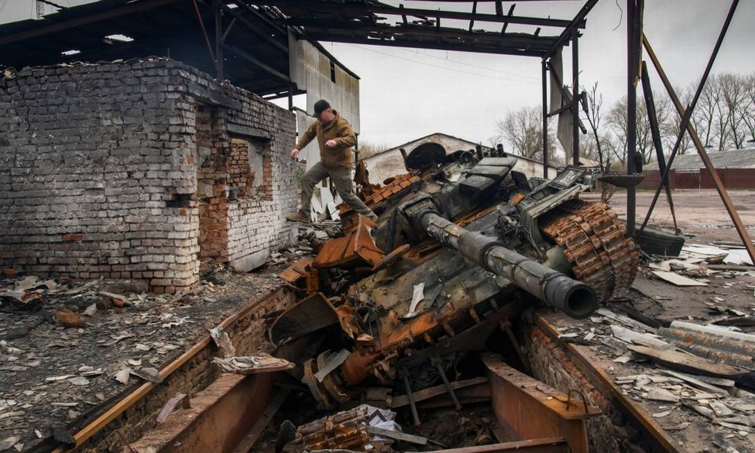 Homem salta de um tanque russo T-72 destruído durante invasão à Ucrânia Foto: STRINGER / REUTERS