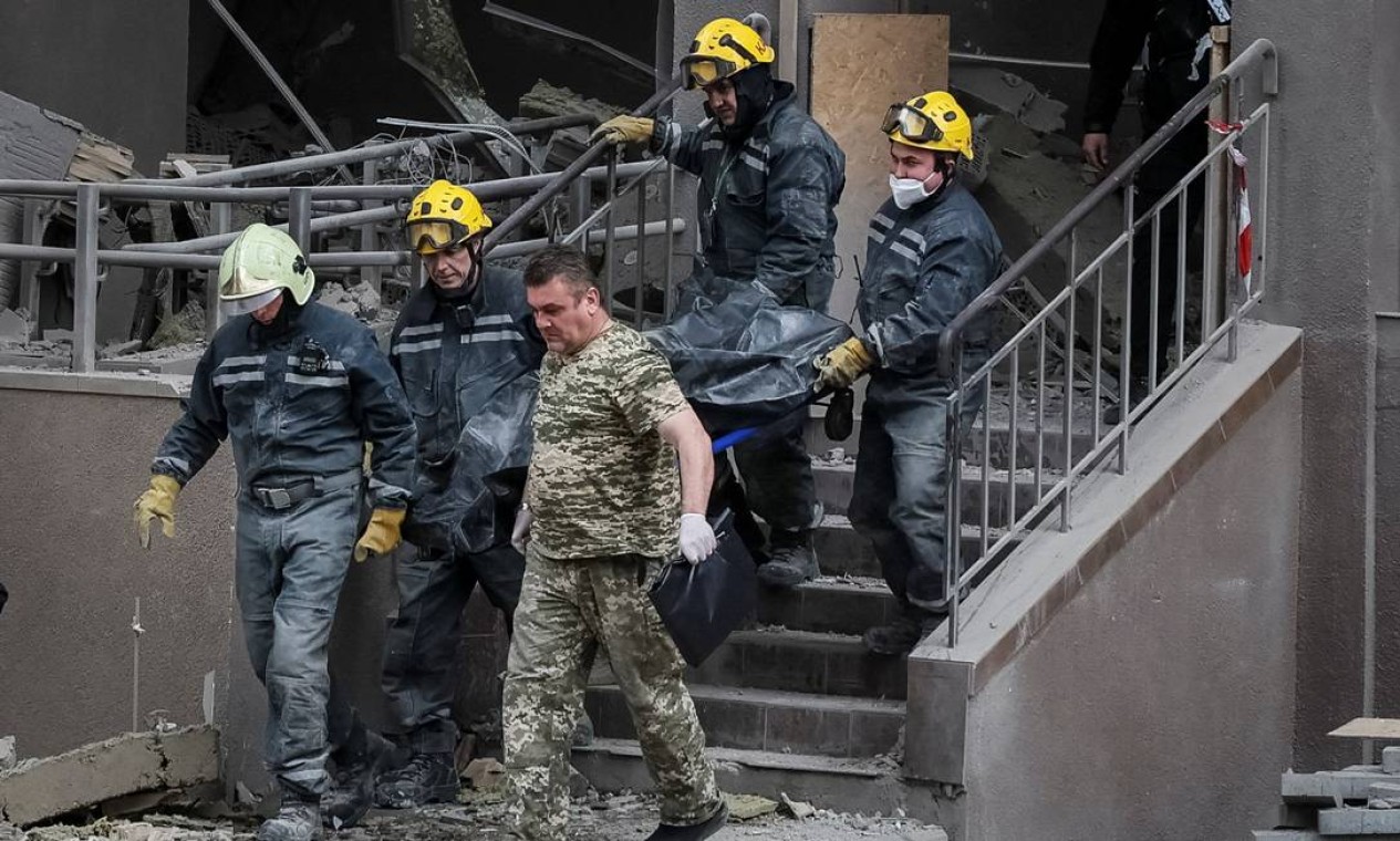 Equipes de resgate carregam o corpo do produtor da Rádio Liberty, Vira Hyrych, morto em um ataque aéreo que teve como alvo um prédio, em meio à invasão russa da Ucrânia, em Kiev Foto: GLEB GARANICH / REUTERS
