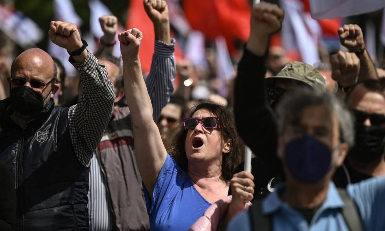 Manifestantes erguem o punho durante ato do Dia Internacional do Trabalhador, em Atenas, Grécia Foto: ARIS MESSINIS / AFP
