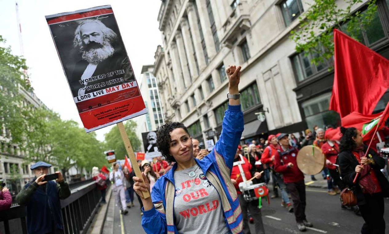 Manifestantes carrega cartaz com retrato de Karl Marx durante uma marcha de protesto em direção à Trafalgar Square, no centro de Londres Foto: JUSTIN TALLIS / AFP