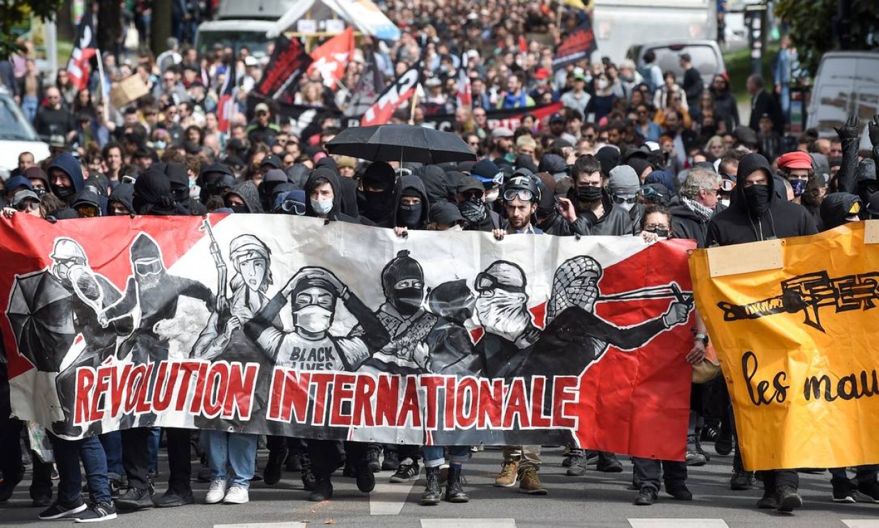 Manifestantes seguram uma faixa com os dizeres "Revolução internacional" durante comício do 1º de Maio em Nantes Foto: SEBASTIEN SALOM-GOMIS / AFP