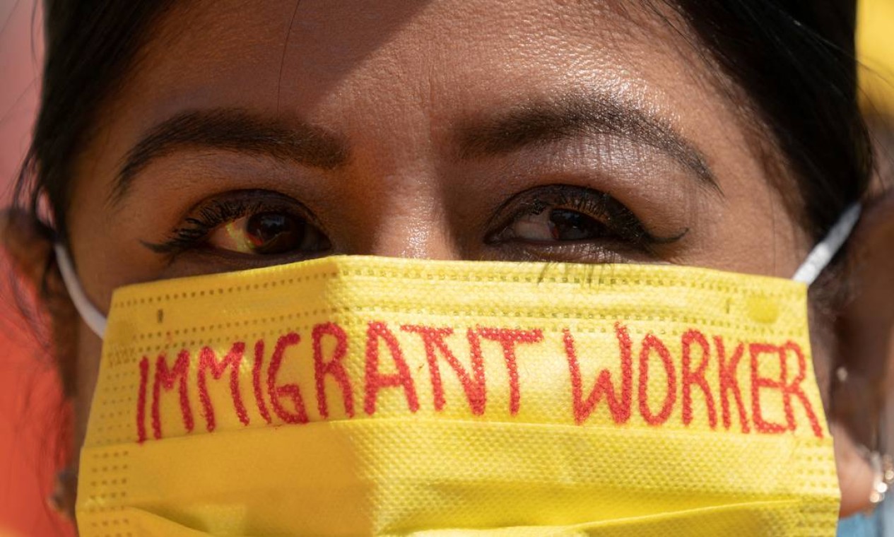 Alejandra Marin usa uma máscara comas palavras "trabalhador imigrante" enquanto participa de protesto durante o Dia Internacional dos Trabalhadores no Washington Square Park, em Nova York Foto: JEENAH MOON / JEENAH MOON / REUTERS