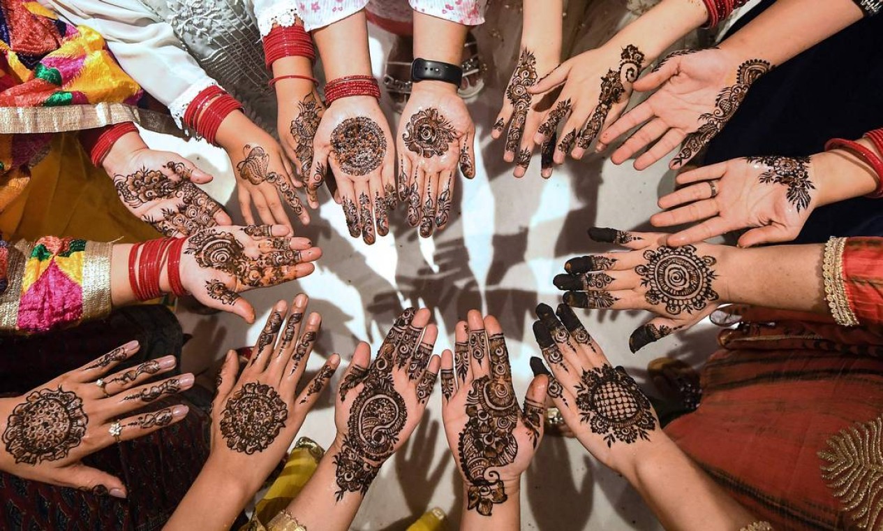 Mulheres mostram tatuagens de henna nas mãos durante 'Chand Raat' ou 'Noite da Lua' em Katmandu, na véspera do festival muçulmano Eid al-Fitr Foto: PRAKASH MATHEMA / AFP
